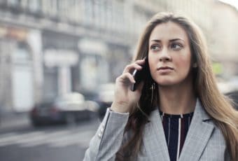 אישה הולכת ברחוב ומוטרדת מינית בשיחת טלפון
